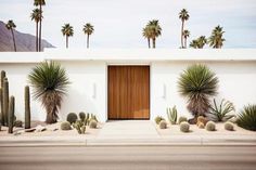 a white house with cactus and cacti around it's front door in the desert