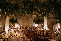 the tables are set up with white linens and greenery for an elegant dinner