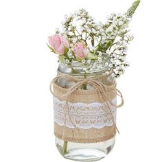 a mason jar filled with pink roses and baby's breath in burlock