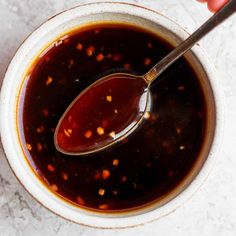 a spoon in a bowl filled with sauce