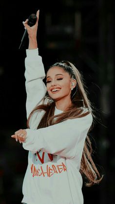 a woman with long hair holding a microphone