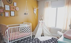 a baby's room with a teepee tent in the corner