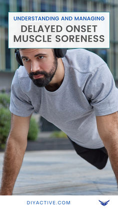 a man in grey shirt and headphones doing push ups