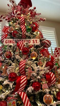 a christmas tree decorated with red and white ribbon