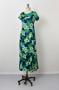 Spring Hawaiian Green Dresses, Green Hawaiian Floral Print Dress, Retro Green Floral Print Maxi Dress, Green Hawaiian Maxi Dress For Spring, Green Retro Maxi Dress With Floral Print, Green Hawaiian Dress With Tropical Print, Green Hawaiian Tropical Print Dress, Fitted Green Maxi Dress With Tropical Print, Green Fitted Tropical Dress