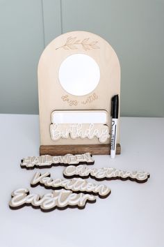 some cut out letters are sitting next to a marker and marker holder on a table