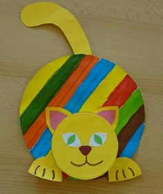 a paper plate with a yellow cat on it's face and stripes in the background