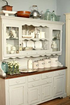 an old fashioned china cabinet with dishes on it