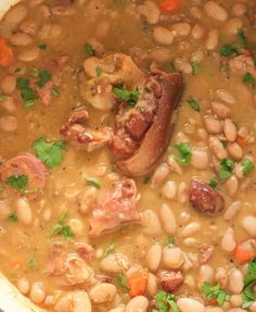 a pot filled with beans and meat on top of a stove