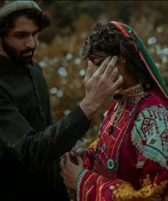 a man and woman standing next to each other with their hands covering their faces in front of them