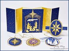 three christmas ornaments are shown in front of an open card with the nativity scene on it