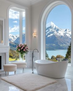 a large bathroom with an oval window overlooking the water and mountains is pictured in this image