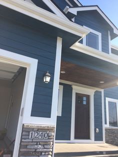 a house with blue siding and white trim on the front door is pictured in this image