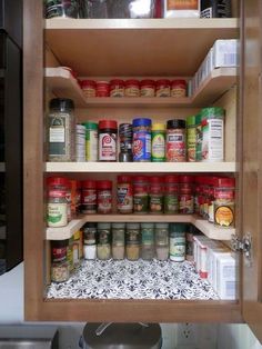 an open cabinet with spices and other items in it