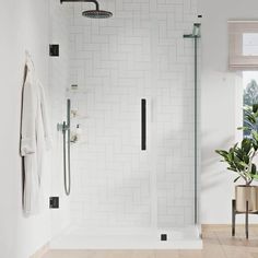 a white tiled bathroom with a glass shower door and black trimming on the walls