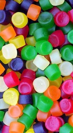 many different colored candy candies are in a pile on the table and there is no image here to provide a caption for