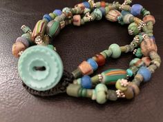 "Bracelet - Modern Tribal Treasure wrap, Turquoise, African Trade beads, Roman glass Beads, Excavated Mali Glass Beads. One of a Kind. Artist: Teresa Bradford Length: 7 1/2\"\" 3 Strands Such a wonderful collection, Ah if beads could talk. This bundle is a treasure trove. * Roman Glass, Egyptian recycled glass, West African Trade beads, Turquoise, Water Buffalo Horn, Excavated mali glass, Venetian Trade beads, Tribal Silver Spacers. Strung on Sturdy upholstery thread. ❤ Teresa Bradford-Cole Sacr Hand-strung Turquoise Beaded Bracelets With Czech Glass, Bohemian Turquoise Beaded Bracelets With Czech Glass, Turquoise Czech Glass Bracelets With Large Beads, Turquoise Czech Glass Beaded Bracelets With Gemstone Beads, Unique Turquoise Czech Glass Beaded Bracelets, Turquoise Beaded Bracelets With Czech Glass Gemstones, Turquoise Glass Round Beads Bracelets, Bohemian Turquoise Glass Bracelets, Handmade Turquoise Glass Beads