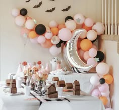 a table topped with lots of balloons and desserts