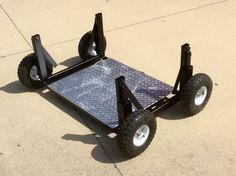 a small cart with wheels on the ground next to a sidewalk and cement flooring