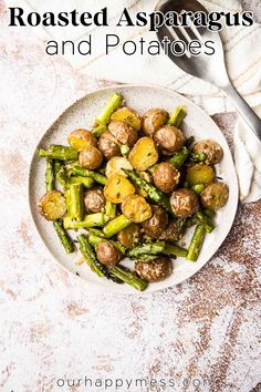 roasted asparagus and potatoes on a white plate with a fork next to it