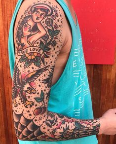 a man wearing a blue tank top with tattoos on his arm