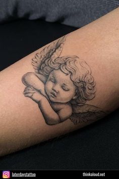 a tattoo on the arm of a woman with an angel holding a baby in her arms