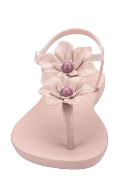 Dimensional floral details blossom on a glossy sandal complete with a sleek thong strap. Adjustable ankle strap Synthetic upper, lining and sole Made in Brazil Hispanic & Latinx Owned/Founded Elegant Beach T-strap Sandals With Adjustable Strap, Spring Jelly Sandals With Adjustable Strap, Summer Flower-shaped Synthetic Flip Flops, Chic Summer Sandals With Flower Design, Chic Flower Sandals For Summer, Elegant Spring Jelly Sandals For Beach, Elegant Flat Jelly Sandals For Spring, Chic Summer Flower Sandals, Elegant Summer Jelly Sandals With Ankle Strap