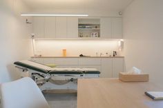 a hospital room with an exam table and medical equipment on the counter top in front of it