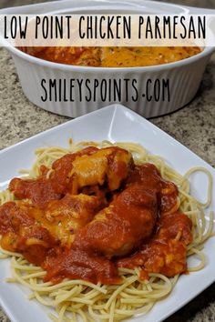 chicken parmesan with spaghetti on a white plate and a bowl of sauce in the background