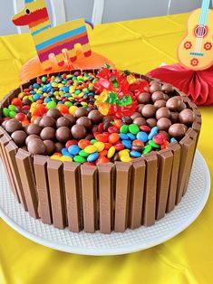 a birthday cake with chocolate frosting and sprinkles on a yellow tablecloth