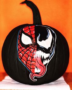 a pumpkin with a spiderman face painted on it