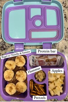 a purple lunchbox with compartments filled with food and labeled labels on the side, including pretzels