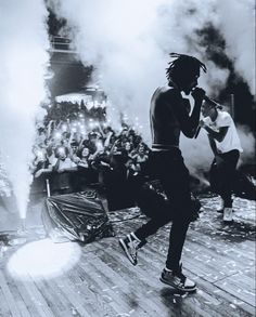 a man with dreadlocks is performing on stage in front of a large crowd