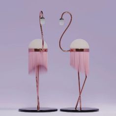 two pink flamingos standing next to each other