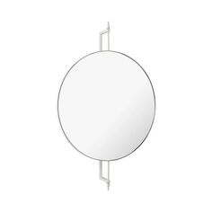 a round mirror hanging on the side of a wall next to a white towel rack