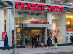 people walking in front of a trader joe's store