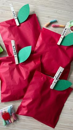 three red bags with green leaves on them and some candy in the bag next to them