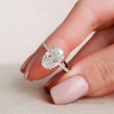 a woman's hand with a ring on her finger and a diamond in the middle