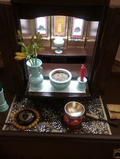 a table with bowls and cups on it in front of a stained - glass window