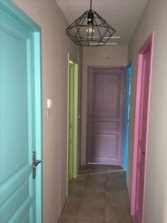 the hallway is painted in different colors and has an iron light fixture hanging from the ceiling