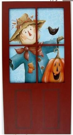 a painting of a scarecrow and pumpkins on a red door