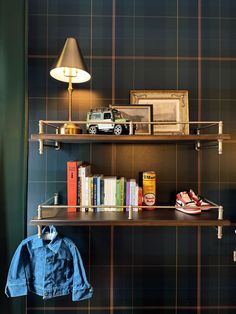 a shelf with some books and shoes on top of it next to a wall mounted lamp