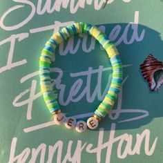 a bracelet that is sitting on top of a sign with the words summer written in it