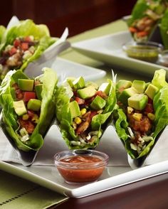 lettuce wraps filled with chicken, avocado and salsa on a tray