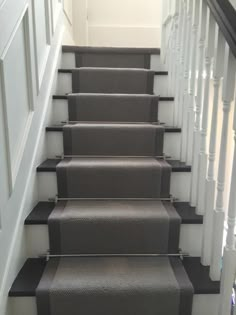 a set of stairs with carpet on the bottom and handrails to the top