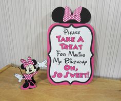 a minnie mouse birthday sign next to a small figurine