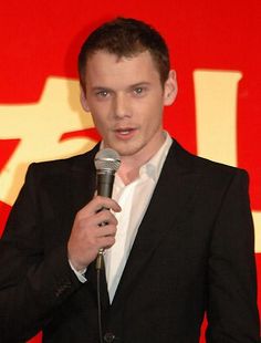 a man in a suit holding a microphone