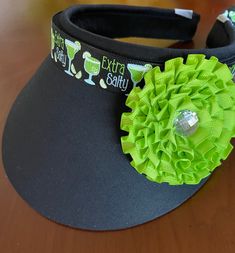 "Glitzy Black or White sun visor decorated with lime green ribbon of cocktail  drinks around the top brim and a lime green ribbon flower attached to the side. It is sure to bring compliments. It is a comfortable open back cotton visor with white terry cloth lined around inside brim for comfort .The visor is an open adjustable clip back, very comfortable. It can be made with ribbon only. Very Happy Customer! All I can say is \"I love this visor\". It's classy looking, and I get lots of compliment Lime Green Ribbon, Hat Decoration, Art Camp, Resort Vacation, Ribbon Flower, Happy Customer, Camping Art, Green Ribbon, Sun Visor