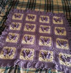 a crocheted blanket is laying on a bed