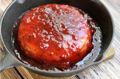 a pan filled with sauce on top of a wooden table